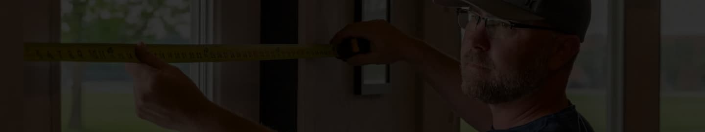 Maintenance worker of WPM measuring a wall with a tape measure
